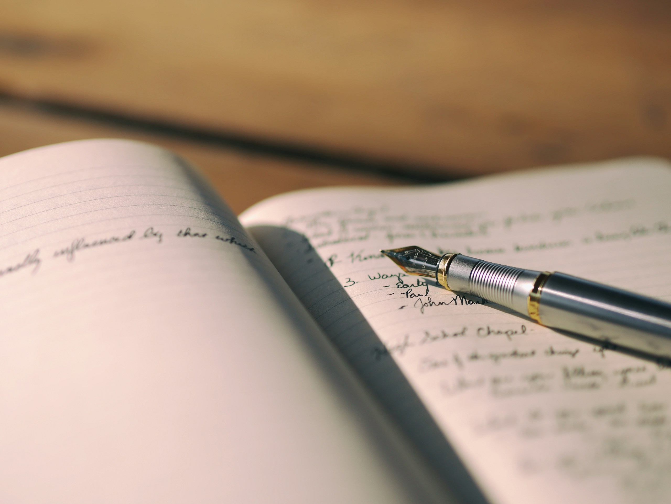 Fountain pen resting on an open lined notebook — the craft of writing applied to real estate listing copy