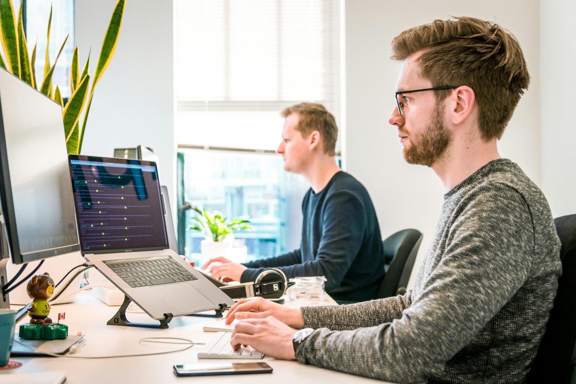 Real estate professional working at a laptop in a bright modern office — reviewing CRM data and lead follow-up workflows