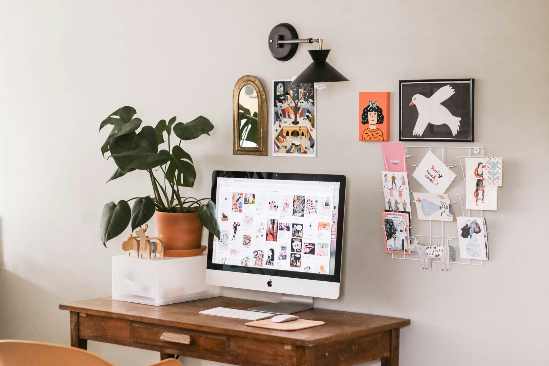 Clean minimal home office with a silver iMac on a wooden desk — the kind of focused workspace a solo agent builds around a streamlined AI tool stack